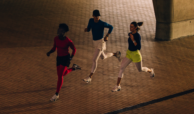 Três pessoas usando o Apple Watch correm juntas