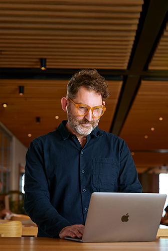An Apple Corporate Functions team member using a MacBook in Caffè Macs.