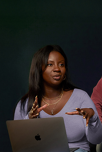 An Apple Software and Services team member sitting on a couch with her MacBook.
