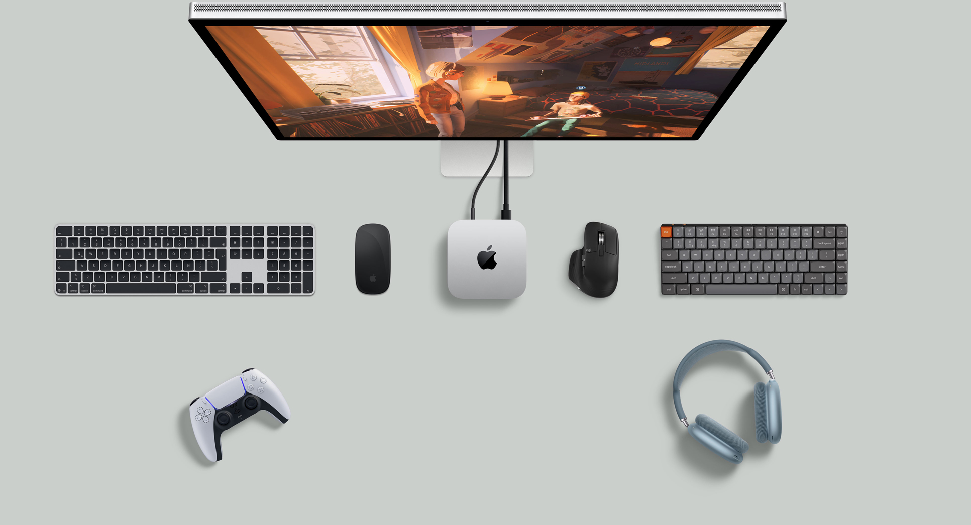 Vista desde arriba de un Mac mini color plata sobre un escritorio, con un monitor, teclados inalámbricos, dos mouse inalámbricos, un control para jugar y unos AirPods Max