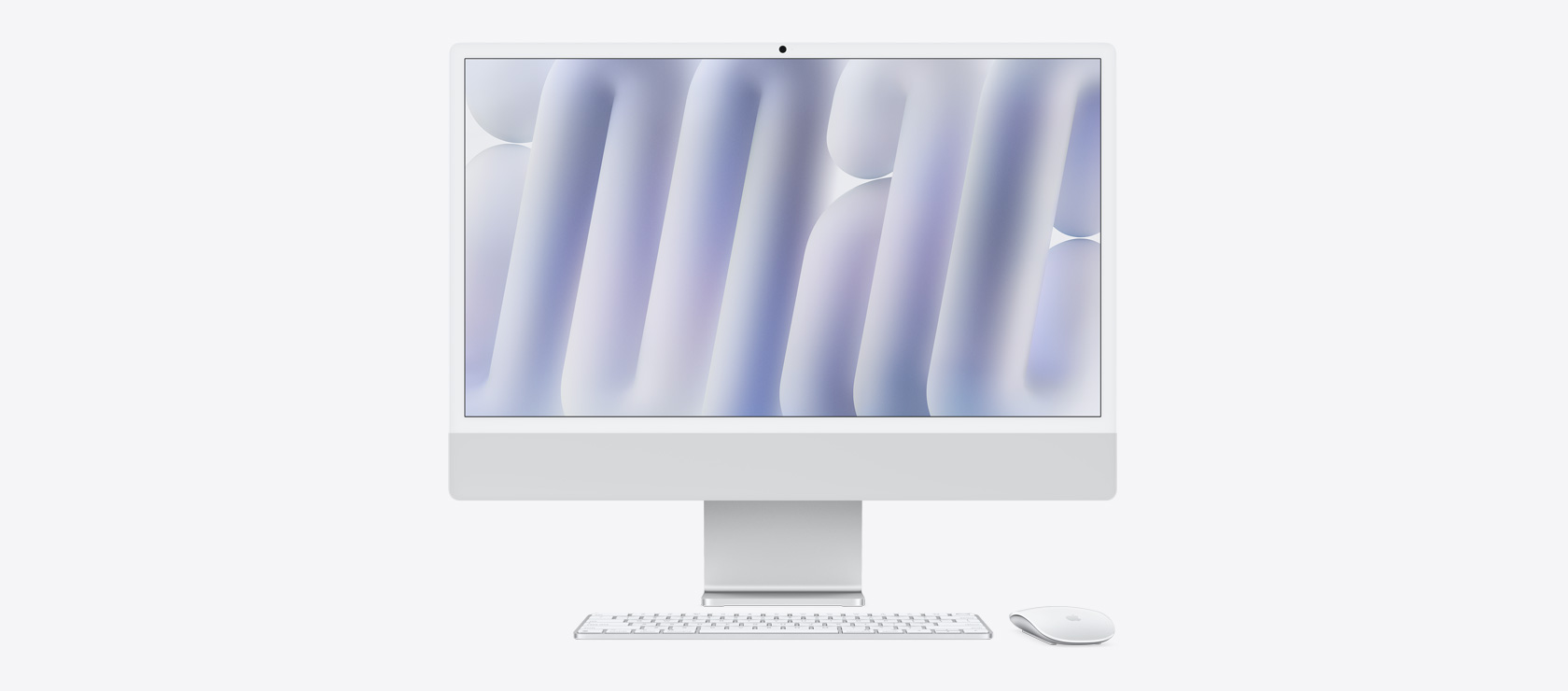 Imagem da frente de um iMac prateado com mouse e keyboard na mesma cor